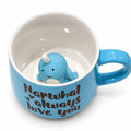 Blue ceramic mug with hidden narwhal figurine and playful text