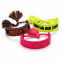 Three woven Christian Dior J'Adior-style bracelets in navy orange, neon yellow, and pink