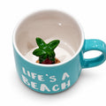 Turquoise Life's a Beach ceramic mug with hidden palm tree figurine